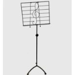 A green painted metal adjustable music stand with treble clef decoration. Width 45.5cm.