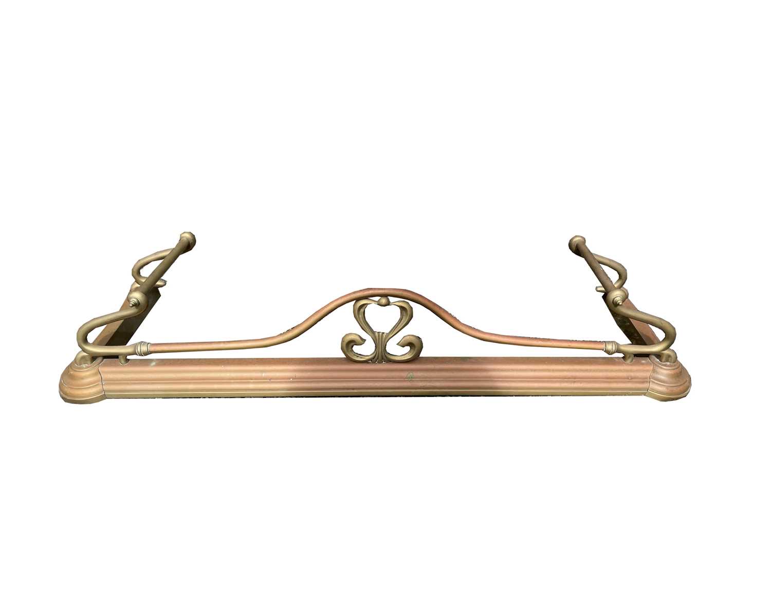 A brass Art Nouveau design fender, with open foliate motif to the centre and whiplash ends, width