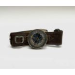 A Japanese World War II pilot's or officer's wrist compass, the plated brass case mounted on a