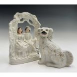 A pair of Victorian Staffordshire pottery figures of spaniels, with gilt decoration and curled