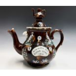 A Measham treacle glazed bargeware teapot, dated 1916, with teapot finial, applied with pheasants,