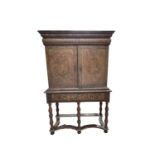 A walnut veneered cabinet on stand, early 18th century, the moulded cornice with a cushion drawer,