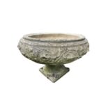 A reconstituted stone planter of circular font form, diameter 68cm, raised on associated base,