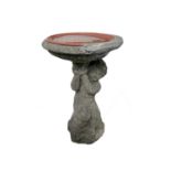 A composite stone bird bath, the column modelled as a kneeling cherub. Height 58cm.