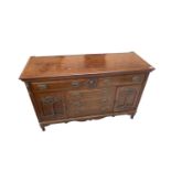 An Art Nouveau mahogany sideboard, with an arrangement of five drawers, and two floral carved doors,