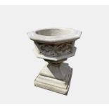 A reconstituted stone Gothic font style planter, the octagonal bowl having relief quatrefoil panels.