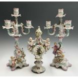 A pair of early 20th century continental porcelain candelabra, with applied figural and floral