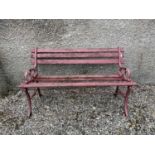 A red painted garden bench, the metal ends cast with leafy scrolls. Width 124cm.