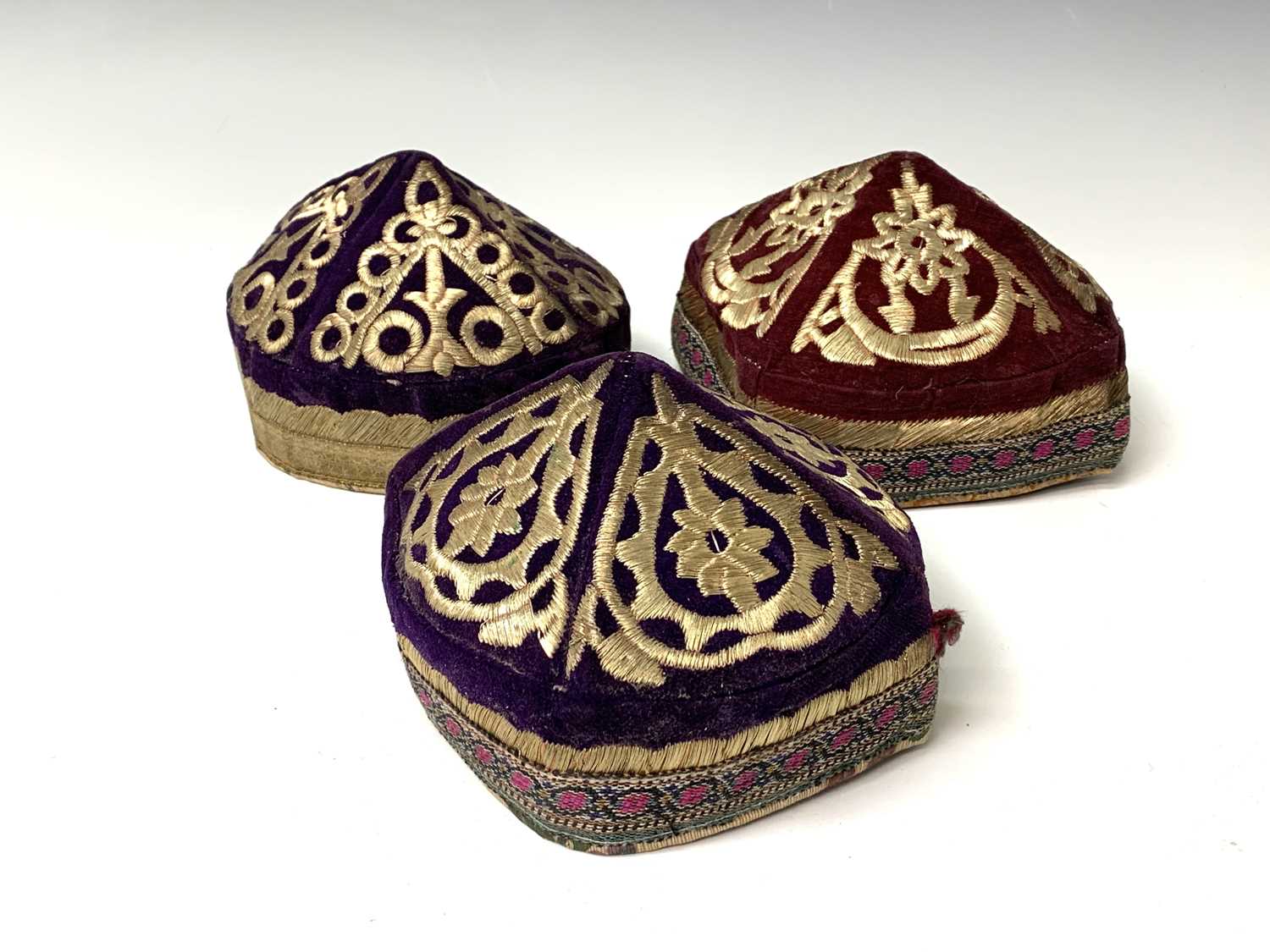 Three eastern skull caps, circa 1920, each embroidered and with gold thread decoration, together a