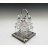 An Edwardian four bottle cruet, on silver plated stand raised on four ball feet. Overall height 21.