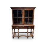 A William and Mary style walnut cabinet on stand, circa 1900, with a pair of glazed doors