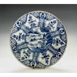 An 18th century English Delft Blue and white large plate, painted centrally with a chinoiserie scene