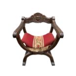 A beech framed Savonarola type armchair with carved frame and curved X shape supports. Height