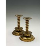 A pair of brass candlesticks, circa 1900, having repousse and chased decoration in the Arts and