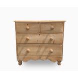 An early 20th century pine chest of drawers, with two short and two long drawers, on bun feet,