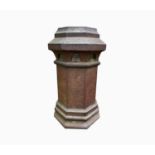 A terracotta octagonal chimney pot with pierced decoration. Height 62cm.