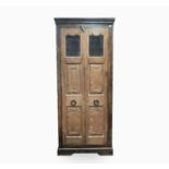 A large Continental elm kitchen cabinet, the pair of doors with grills and carved panels, on bracket