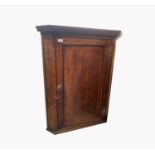 A George III oak and fruitwood banded corner cupboard, with dentil cornice, brass H hinges and