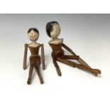 Two carved wood and painted peg dolls, length 30cm.