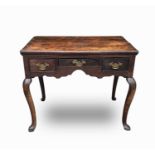 A George III oak lowboy, with three frieze drawers above a shaped apron, on cabriole legs with pad