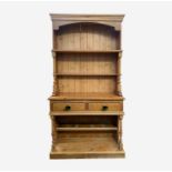 A pine kitchen dresser, the rack with turned columns flanking the shelves, the lower part with two
