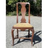 A George II walnut chair, the vase shaped splat above a drop in seat on cabriole legs and pad feet