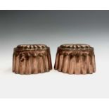 A pair of copper jelly moulds, 19th century, the tops with embossed paterae and fluted sides, each