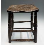 An elm stool, 19th century, the dished seat on turned legs joined by stretchers, height 48cm,