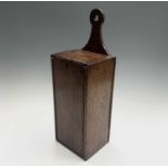 A George III oak candle box, with sliding front panel, height 49.5cm, width 16.5cm, depth 14.5cm.