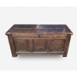 A carved oak coffer, 17th century, with arch carved frieze and triple panelled front, on stile feet,