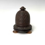 A 19th century treen string box, in the form of a beehive, raised on bun feet, height 11.5cm,