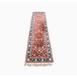 A North West Persian runner, with an all over design of scrolling flowering vines, within an