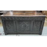 A 17th century carved oak coffer, with a later lid, the triple panelled front with geometric motifs,