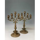 A pair of Gothic style bronze candelabra, circa 1900, each with five stepped sconces with pierced