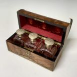 A Victorian figured walnut brass bound casket, the domed top opening to reveal three glass scent