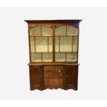 A Victorian pine kitchen dresser, the upper part with two glazed doors enclosing shelves, the