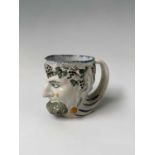 An English pearlware satyr jug, early 19th century, decorated in Pratt colours, height 8.7cm,