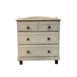 A Victorian white painted pine chest of drawers, with a solid gallery above two short and two long
