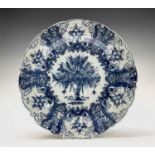 A Dutch Delft dish, 18th century, painted in blue with a central vase of flowers, diameter 35.5cm.