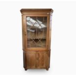 A 19th century pine standing corner cupboard, with an astragal glazed door enclosing three