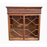 A pitch pine hanging display cupboard, late 19th century, with blind fret cut frieze above two