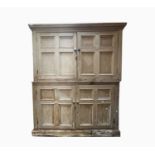 A pine kitchen cupboard, early 20th century, distressed, in two sections, with two quarter