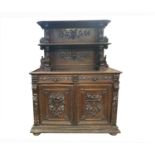 A carved oak buffet, 19th century, the upper tier with two shelves, the base with a pair of