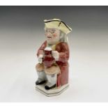 A Staffordshire Toby jug, 19th century, the seated gent holding a pipe and a jug of ale, height