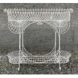 A Victorian wrought iron conservatory plant stand, with ornate scrolled and arcaded decoration,