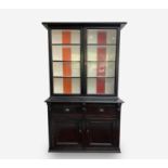 A Victorian pine black painted bookcase, with a pair of glazed doors enclosing four shelves, the