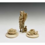 A Japanese carved ivory okimono, Meiji period, of a man carrying a fish on his shoulder and a boy at