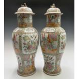 A large pair of Chinese Canton famille rose vases and covers, 19th century, decorated with panels of