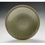 A Chinese Chekian Celadon dish, late Ming period, decorated with a central moulded floral medallion,