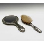 A hallmarked silver-backed hairbrush and a silver-plated hand mirror, both decorated with the '